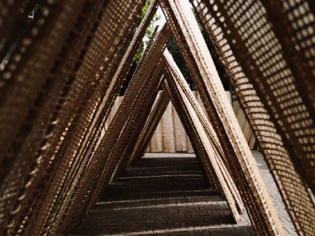 Repeating woven bamboo triangular frames forming a passageway